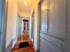A hallway with beautiful hardwood floors, built-in storage, and a view into a parlor at 900 Carlton Ave, Lake Wales, FL 33853