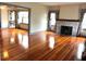 Open living room with hardwood floors, brick fireplace, and doorway leading to the dining room at 900 Carlton Ave, Lake Wales, FL 33853
