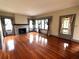 Spacious living room featuring gleaming hardwood floors, a brick fireplace, and abundant natural light at 900 Carlton Ave, Lake Wales, FL 33853