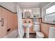 Charming bathroom with pink tile, pedestal sink, and bathtub with shower at 915 Oregon St, Orlando, FL 32803