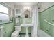 Green bathroom featuring a pedestal sink, shower/tub, and built-in cabinet at 915 Oregon St, Orlando, FL 32803