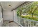 View from a covered front porch with tile floor and white railing overlooking the landscaped front yard at 927 Boardman St, Orlando, FL 32804
