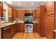 Traditional kitchen with wooden cabinets, stainless steel appliances, granite countertops and backsplash, offering functionality and style at 927 Boardman St, Orlando, FL 32804