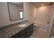 Modern bathroom features granite counters, gray cabinets, and a combined tub and shower at 971 Desert Candle Dr, Ocoee, FL 34761