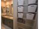 Bathroom with double vanity with granite countertop, framed mirrors, and convenient shelving unit at 971 Desert Candle Dr, Ocoee, FL 34761