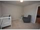 Bedroom featuring a white crib, a grey rocker, and view of another room at 971 Desert Candle Dr, Ocoee, FL 34761