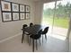 Modern dining area with black table and chairs, view of backyard through sliding glass door at 971 Desert Candle Dr, Ocoee, FL 34761