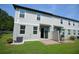 Back exterior of home with sliding glass doors to the paved patio and green lawn at 971 Desert Candle Dr, Ocoee, FL 34761