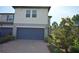 Inviting exterior with a blue garage door, brick driveway, and meticulously maintained landscaping at 971 Desert Candle Dr, Ocoee, FL 34761
