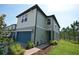 Two-story townhouse with brick walkway leading to blue front door and garage with landscaped green space at 971 Desert Candle Dr, Ocoee, FL 34761
