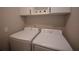 Well-lit laundry room with a modern washer and dryer, and upper cabinets for storage at 971 Desert Candle Dr, Ocoee, FL 34761