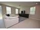 Bright living room featuring a large white sectional sofa, media center, and tile flooring at 971 Desert Candle Dr, Ocoee, FL 34761