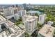 An aerial view of the condo building in a vibrant city setting with a lake and skyline backdrop at 100 S Eola Dr # 1406, Orlando, FL 32801