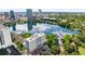 Stunning aerial view of a luxury building overlooking a scenic lake with a beautiful skyline backdrop at 100 S Eola Dr # 1406, Orlando, FL 32801