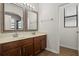 Bathroom with double vanity, two mirrors, tiled floor, and natural light at 10111 Tierra Bella Dr, Orlando, FL 32825