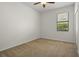Bedroom with carpet, ceiling fan, and a window overlooking greenery at 10111 Tierra Bella Dr, Orlando, FL 32825