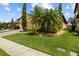 Landscaped front yard featuring lush green grass and mature trees adding shade and character to the home at 10111 Tierra Bella Dr, Orlando, FL 32825