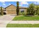 Inviting single-story home with a well-manicured lawn and paver driveway, showcasing curb appeal at 10111 Tierra Bella Dr, Orlando, FL 32825