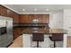 Modern kitchen with dark wood cabinets, granite countertops, stainless steel appliances, and breakfast bar at 10111 Tierra Bella Dr, Orlando, FL 32825