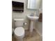 Cozy bathroom with white fixtures including a pedestal sink and toilet, complemented by neutral wall colors at 10148 Malpas Pt, Orlando, FL 32832