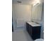 Bathroom with double sink vanity, framed mirror and tile flooring at 10148 Malpas Pt, Orlando, FL 32832