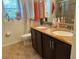 Bathroom featuring a double sink vanity, toilet, and window providing ample natural light at 10148 Malpas Pt, Orlando, FL 32832