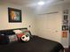 Comfortable bedroom with black bedding, colorful wall art, and built in closet space at 10148 Malpas Pt, Orlando, FL 32832