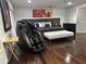 Bedroom with hardwood floors, modern black bed and massage chair, along with contemporary art pieces at 10148 Malpas Pt, Orlando, FL 32832