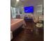 A bedroom with a comfortable pink bed, entertainment center with television, and vanity with mirror at 10148 Malpas Pt, Orlando, FL 32832