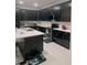 Modern kitchen with dark cabinets, stainless steel appliances, and a center island at 10148 Malpas Pt, Orlando, FL 32832