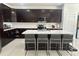 Modern kitchen featuring dark wood cabinets, stainless steel appliances, and a large white center island with seating at 10148 Malpas Pt, Orlando, FL 32832
