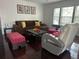 Comfortable living area featuring a brown couch, accent chair, and natural light from the large window at 10148 Malpas Pt, Orlando, FL 32832