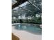 Screened in pool and spa features a waterfall and chairs for relaxing with outdoor views at 10148 Malpas Pt, Orlando, FL 32832