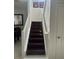 Elegant dark wood staircase with white railings leading to the upper level at 10148 Malpas Pt, Orlando, FL 32832