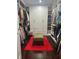 Large walk-in closet with well-organized shelving, hanging racks, and center ottoman on a vibrant rug at 10148 Malpas Pt, Orlando, FL 32832