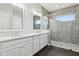 Bathroom featuring a double vanity with white countertop and cabinetry and a glass enclosed shower at 10203 Henbury St, Orlando, FL 32832