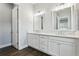 Bathroom featuring double vanity with white countertop and cabinetry with a view into another room at 10203 Henbury St, Orlando, FL 32832