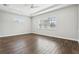 Spacious bedroom with wood-look tile flooring, ceiling fan, and tray ceiling at 10203 Henbury St, Orlando, FL 32832