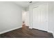 Bedroom featuring wood floors, a closet with white sliding doors, and white trim throughout at 10203 Henbury St, Orlando, FL 32832