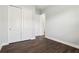 Bedroom featuring wood floors, a closet with white sliding doors, and white trim throughout at 10203 Henbury St, Orlando, FL 32832