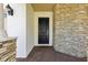 A beautiful, modern home entrance featuring a black front door and stone accent wall at 10203 Henbury St, Orlando, FL 32832
