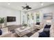Bright living room with dark wood floors, ceiling fan, and sliding glass doors, staged with modern decor at 10203 Henbury St, Orlando, FL 32832