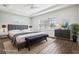 Virtually staged main bedroom boasting tray ceiling, neutral walls, and a large window at 10203 Henbury St, Orlando, FL 32832