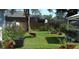 Lush backyard with a mix of greenery, flower pots, and a rustic wheelbarrow, creating a vibrant outdoor space at 1102 S Oak Ave, Sanford, FL 32771
