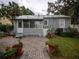 Cozy backyard with brick patio, lush greenery, and a charming cottage-style home at 1102 S Oak Ave, Sanford, FL 32771