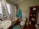 Bathroom with clawfoot tub, floral shower curtain and hardwood floors at 1102 S Oak Ave, Sanford, FL 32771