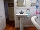 Traditional bathroom featuring a pedestal sink, hardwood floors, and paneled walls at 1102 S Oak Ave, Sanford, FL 32771