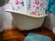 Close up of a clawfoot tub with a floral shower curtain in the bathroom at 1102 S Oak Ave, Sanford, FL 32771