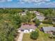 Aerial view of a charming single-story home surrounded by lush trees in a quiet neighborhood near a lake at 1113 Leeward Dr, Deltona, FL 32738