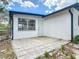 View of the back patio area featuring a door, window, a paved stone patio and white walls at 1113 Leeward Dr, Deltona, FL 32738